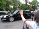 Onlookers wave and cheer as the limousine carrying President Obama and President Medvedev drives by