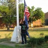 A school employee raises flags outside Wakefield High School A school employee raises flags outside Wakefield High School