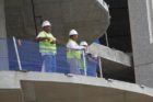 Construction workers look on as an injured colleague is rescued