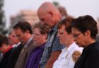Arlington's sheriff, police chief and county manager bow their heads during a prayer