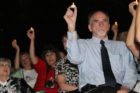 Audience members hold candles in the air