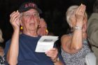 Audience members hold candles in the air