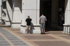 Two men recharge their cell phones outside in Courthouse on Saturday