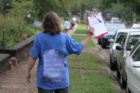 A woman protests changes in bus service outside Oakridge Elementary School