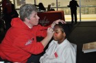 A child has his face painted with the Capitals logo during Monumental Sports & Entertainment’s Family-to-Family holiday party at Kettler Capitals Iceplex