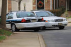 Arlington County police cars watch a  townhouse that was searched earlier by the FBI