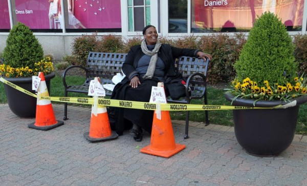Unfazed by 'wet paint' signs, a woman sits on her favorite bench on Crystal Drive