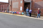 Campaign workers pass out sample ballots outside Arlington Traditional School