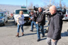 An animal worker walks a dog in front of news cameras
