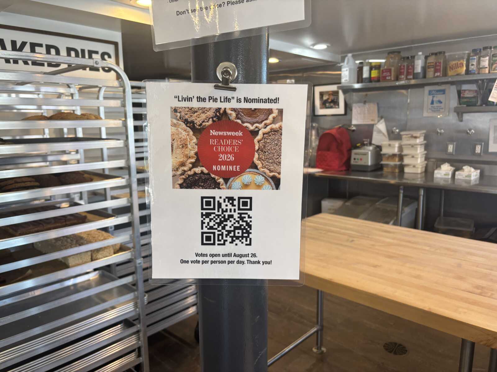 Poster on a pole announcing 'Livin' the Pie Life' nominated for Newsweek Readers' Choice 2026, with a QR code beneath.