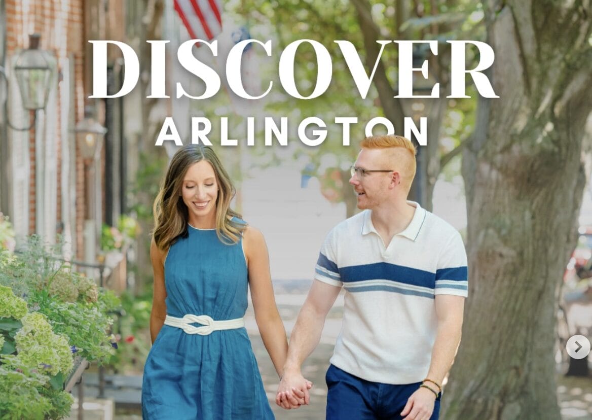 Blake and Leah Davenport on their popular Instagram account (via discoverarlington/Instagram) | ARLnow Couple walking hand-in-hand on a sunny street with greenery and storefronts; large'DISCOVER ARLINGTON' text overlay.