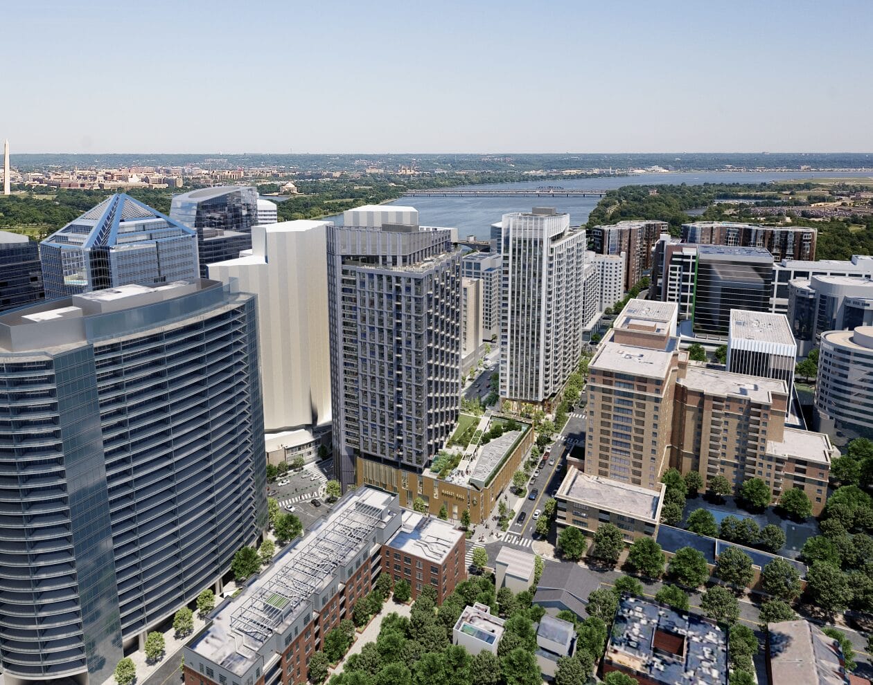Aerial view of a modern city skyline with tall glass office buildings along a river, and a distant bridge.