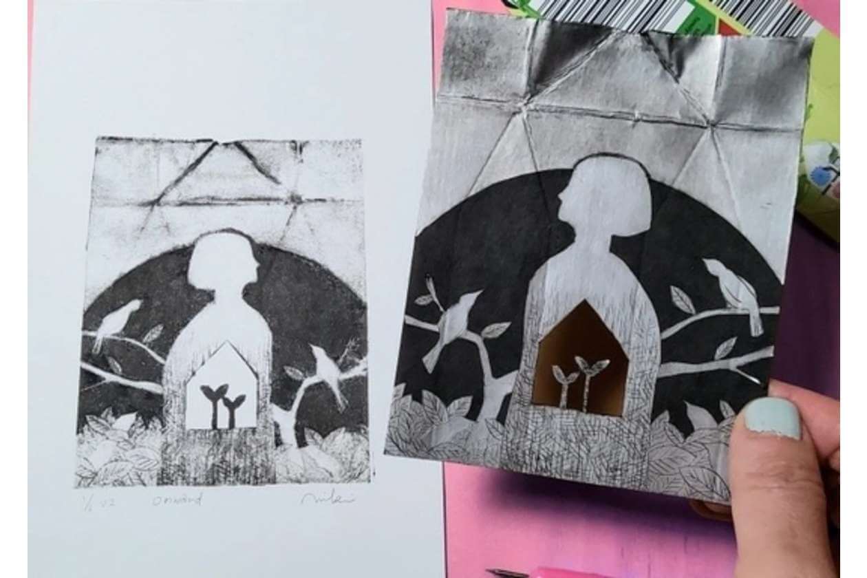 Two monochrome art prints show a white silhouette inside a house-shaped frame against a dark, leafy background; a hand holds the right print.