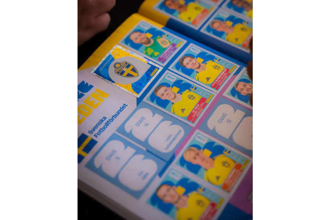 Sheet of colorful trading cards featuring people in yellow jerseys laid out on a table, Sweden flag emblem visible on one card.