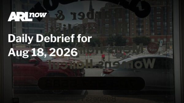 Hero banner for ARL Now reading 'Daily Debrief for Aug 18, 2026' over a city street seen through a glass storefront window with parked cars and buildings in the background