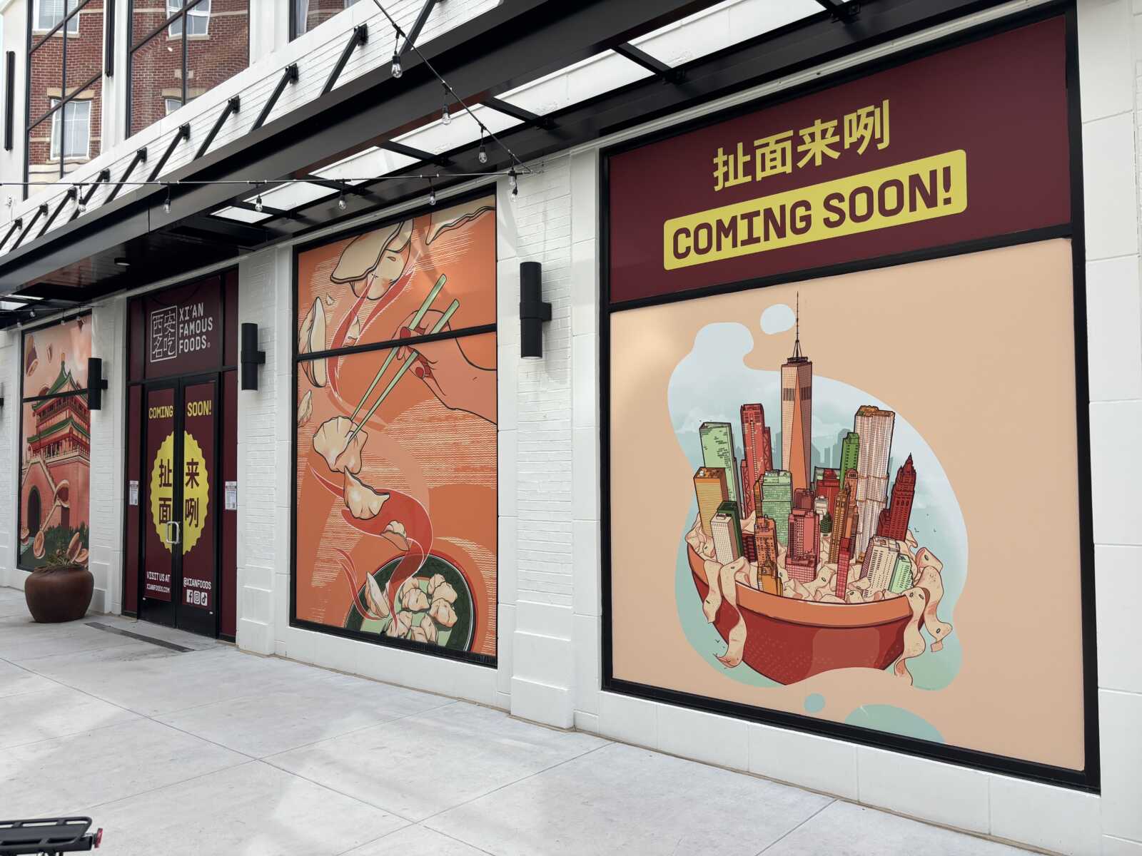 Storefront with colorful murals advertising an upcoming restaurant; a yellow 'COMING SOON!' sign and Xi'an Famous Foods branding visible above the door.