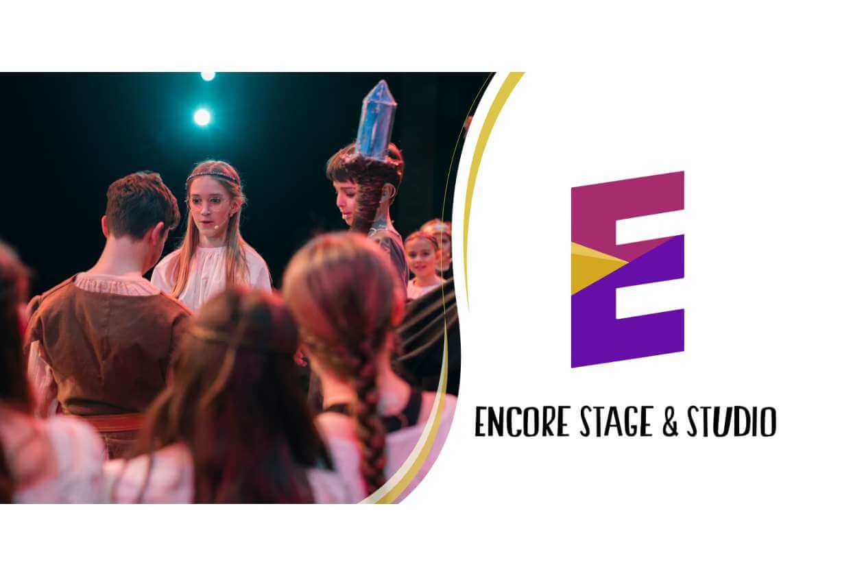 Young performers in period costumes gathered on a stage rehearsal, with the Encore Stage & Studio logo visible on the right.