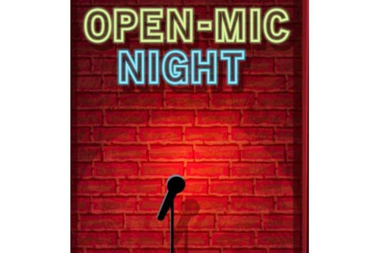 Neon sign reading OPEN-MIC NIGHT above a mic on a stand against a brick wall.