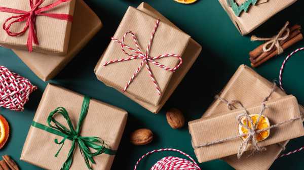 Gift boxes wrapped in brown paper with red, green, and rope ribbons on a green background.