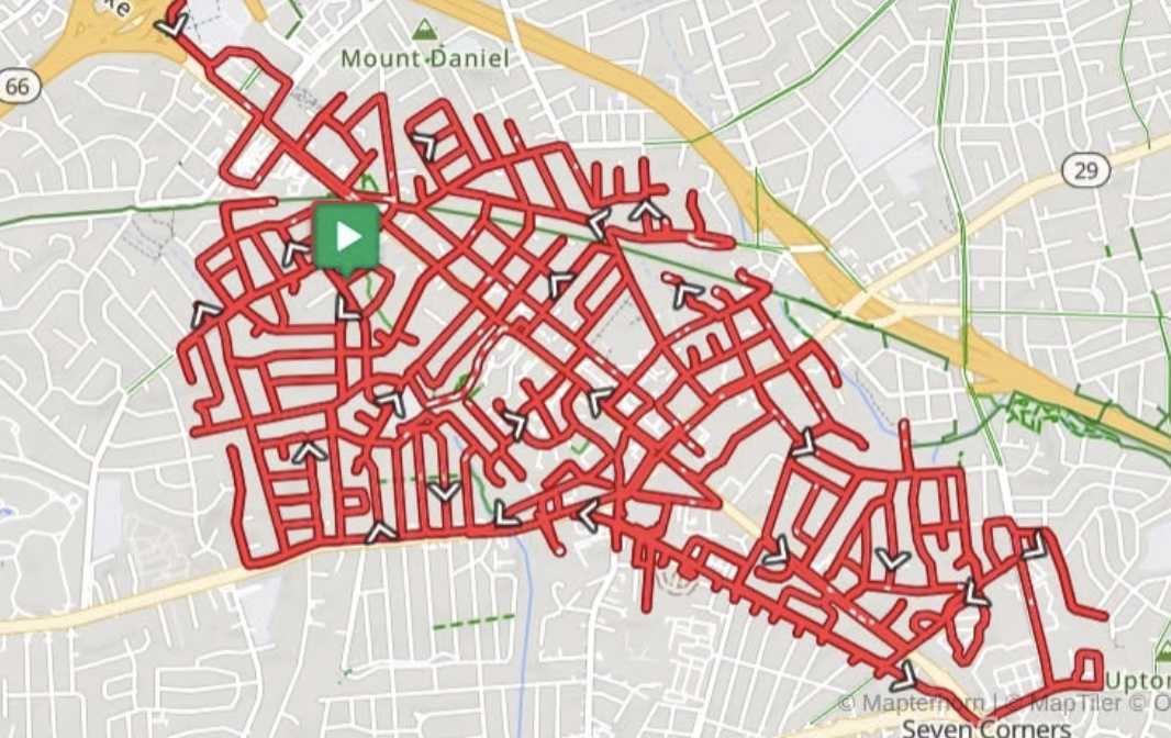City map with tangled red GPS routes surveyed around downtown; a green play button sits at the center.