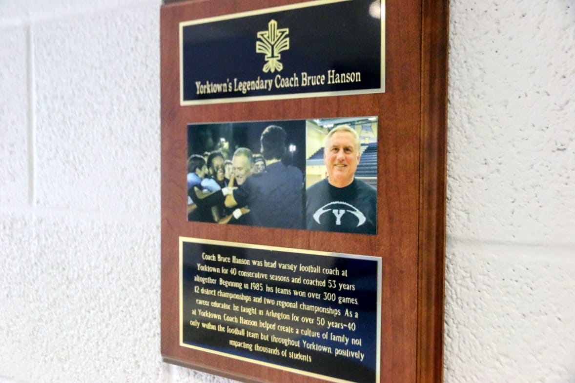 Wooden tribute plaque for Yorktown's legendary football coach Bruce Hanson, with photos and a biography section.