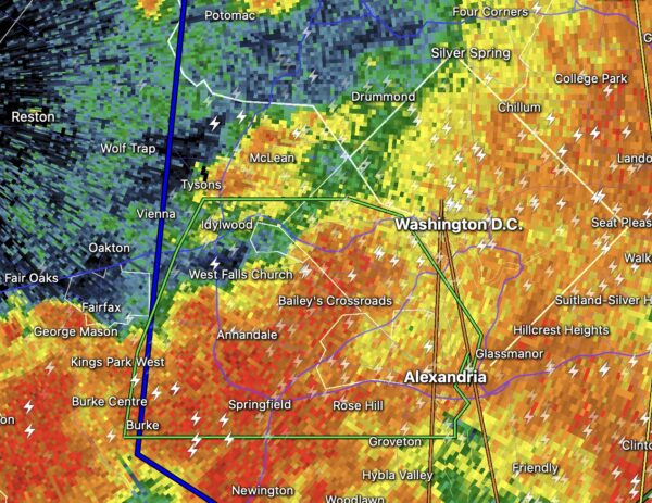 Weather radar over the Washington, DC area showing colorful precipitation bands (green→yellow→orange→red) and lightning bolts near Alexandria and Burke.