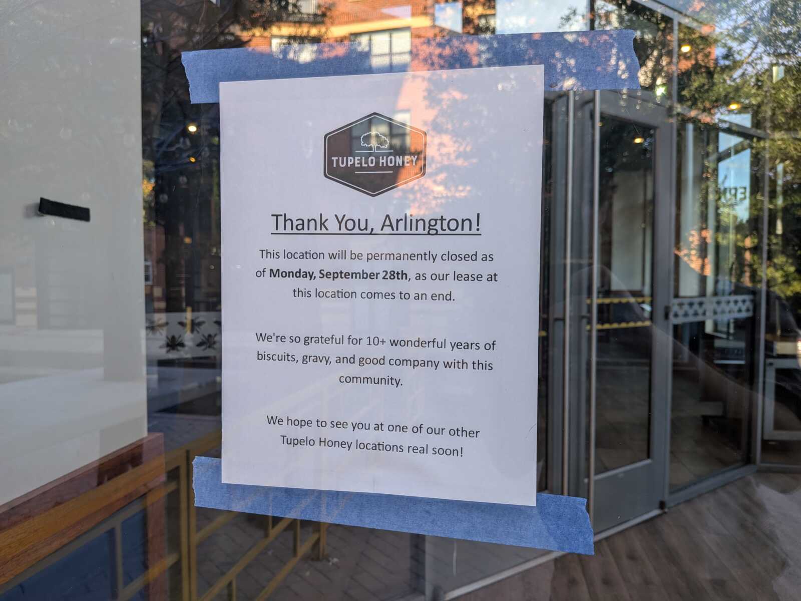 Poster taped to a storefront window reads 'Thank You, Arlington!' and announces permanent closure on Monday, Sept. 28, with thanks to the community (Tupelo Honey logo at top).”