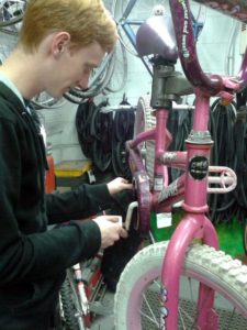 Brian Burgess, a W-L 11th grader, working on one of the bikes to be given away (courtesy photo)