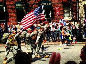Albert Kim (to the right of the flag) running in the 2013 Boston Marathon