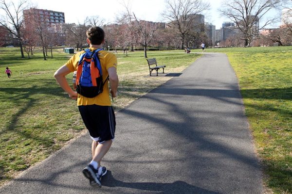 A man jogging through a park on a spring day